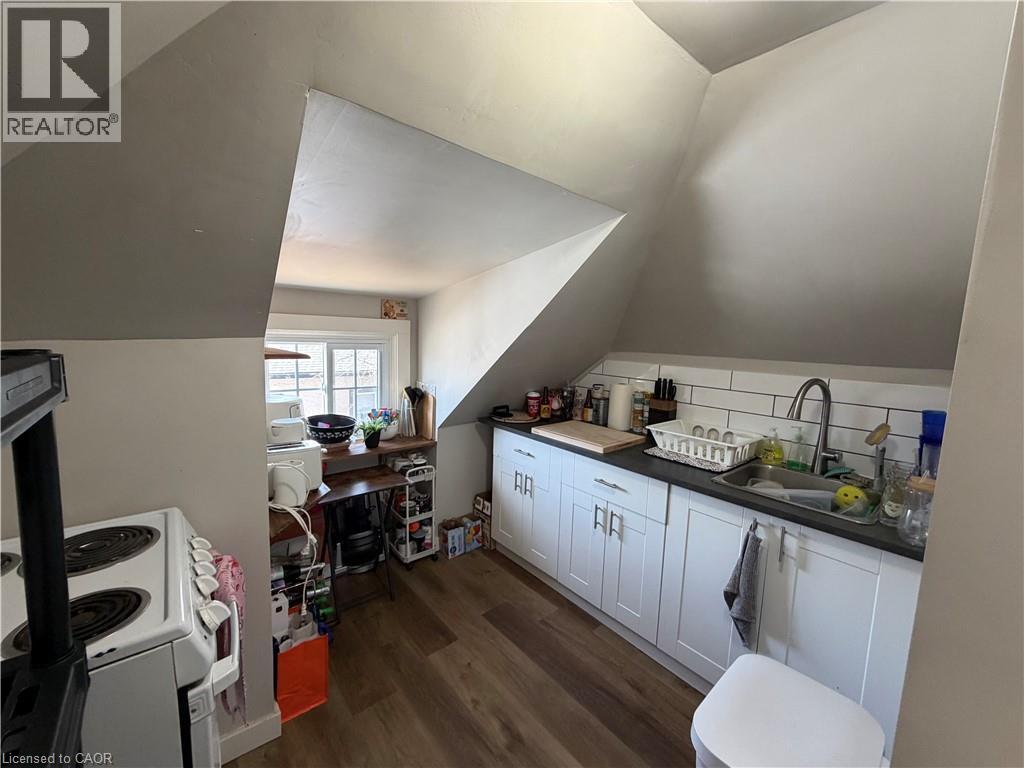 A kitchen with white cabinets and a wooden floor.