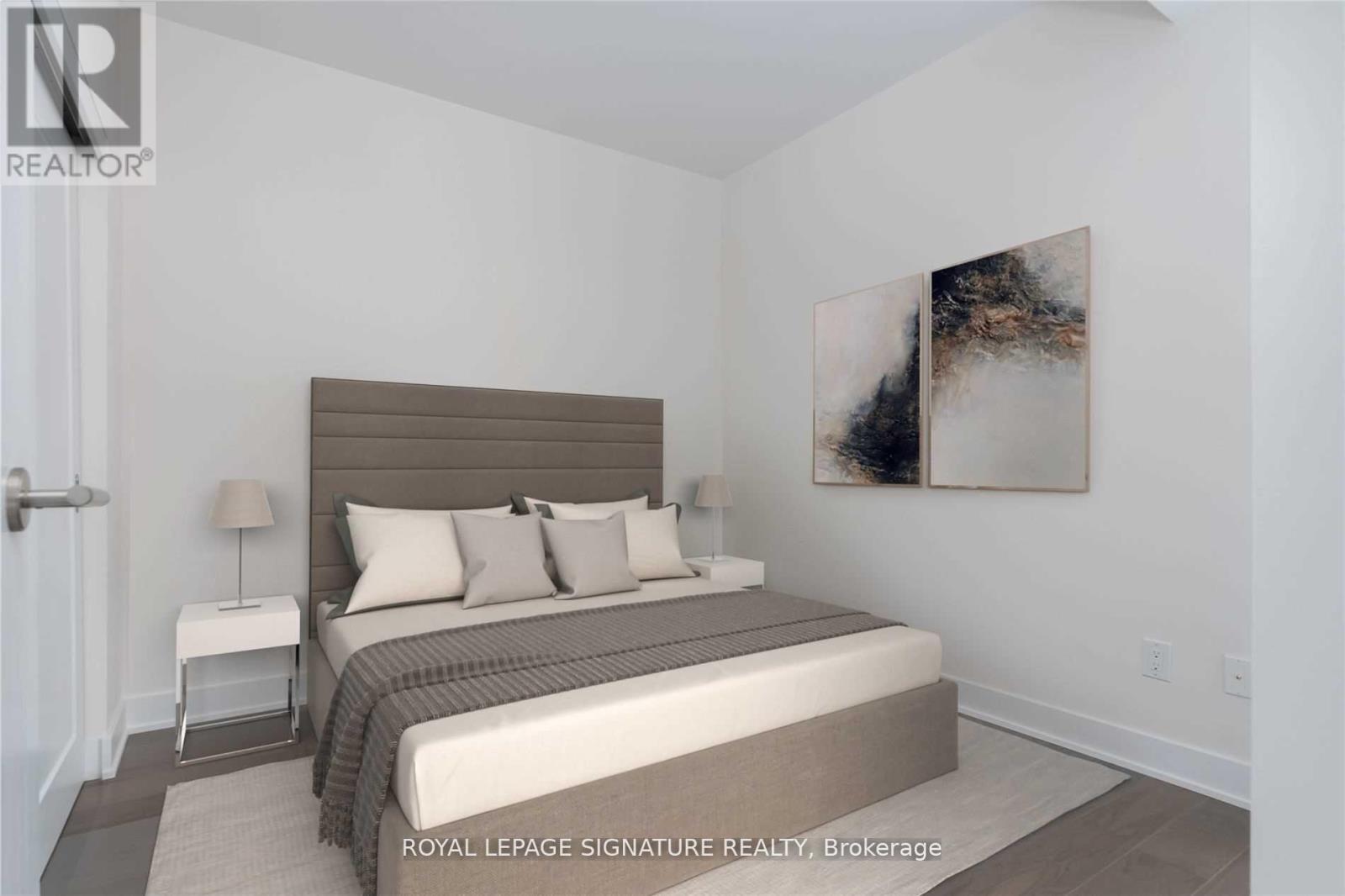 A bedroom with a large bed and a painting on the wall.