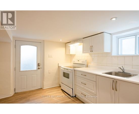 A kitchen with white cabinets and a white oven.