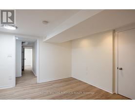 A hallway with wood floors and white walls.