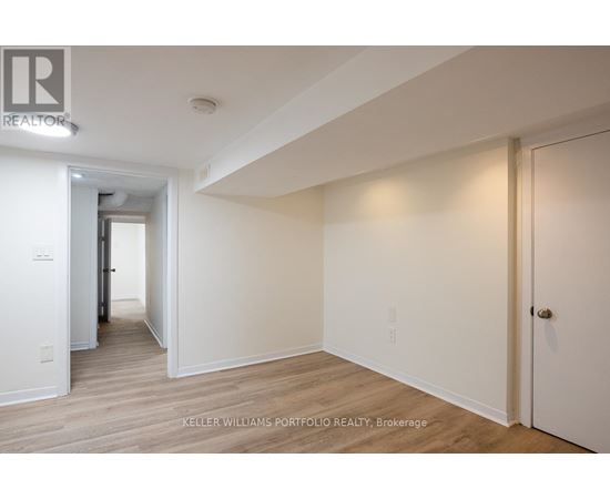 A hallway with wood floors and white walls.