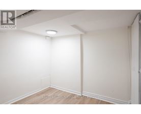 A white empty room with a light on the ceiling.