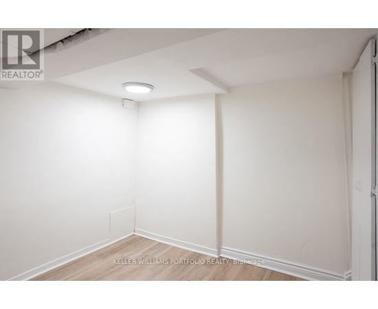 A white empty room with a light on the ceiling.