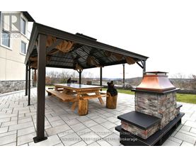 A patio with a table and chairs under a roof.