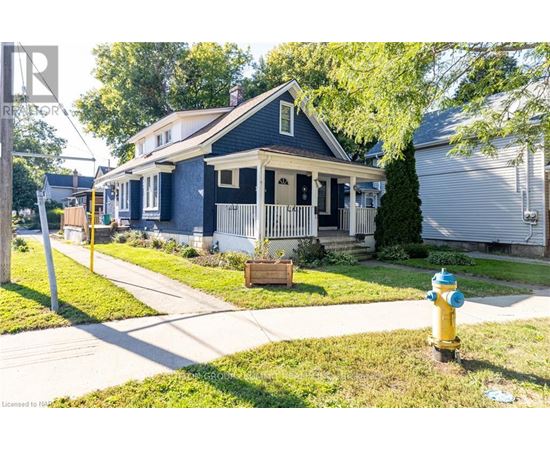 A blue house with a white porch and a yellow fire hydrant in front.