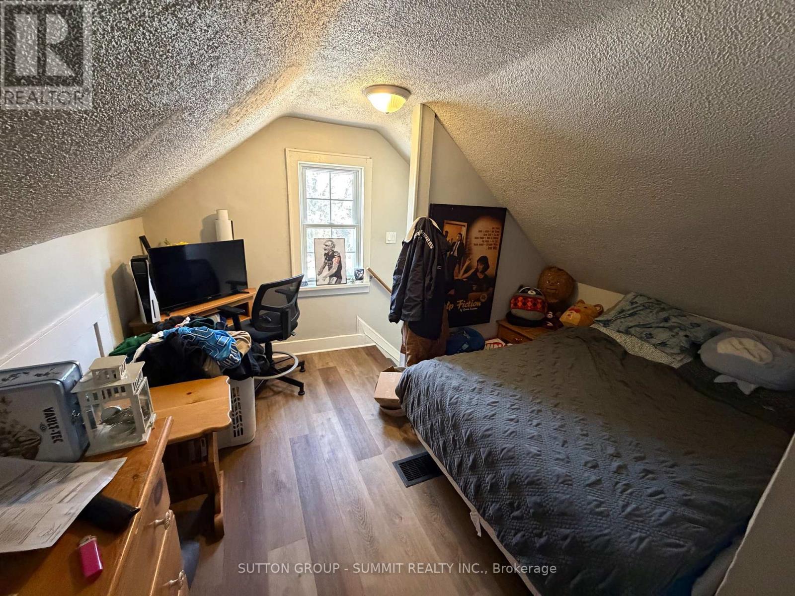 A bedroom with a bed, desk, and chair.