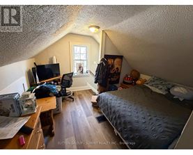 A bedroom with a bed, desk, and chair.