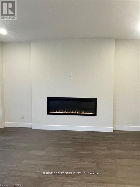 A living room with a fireplace and wood flooring.