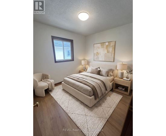 A bedroom with a bed, nightstand, and chair.