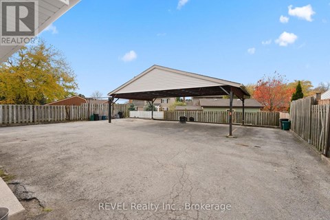 A large, open, fenced area with a building in the background.