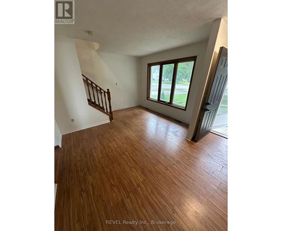 A room with wooden flooring and a staircase.