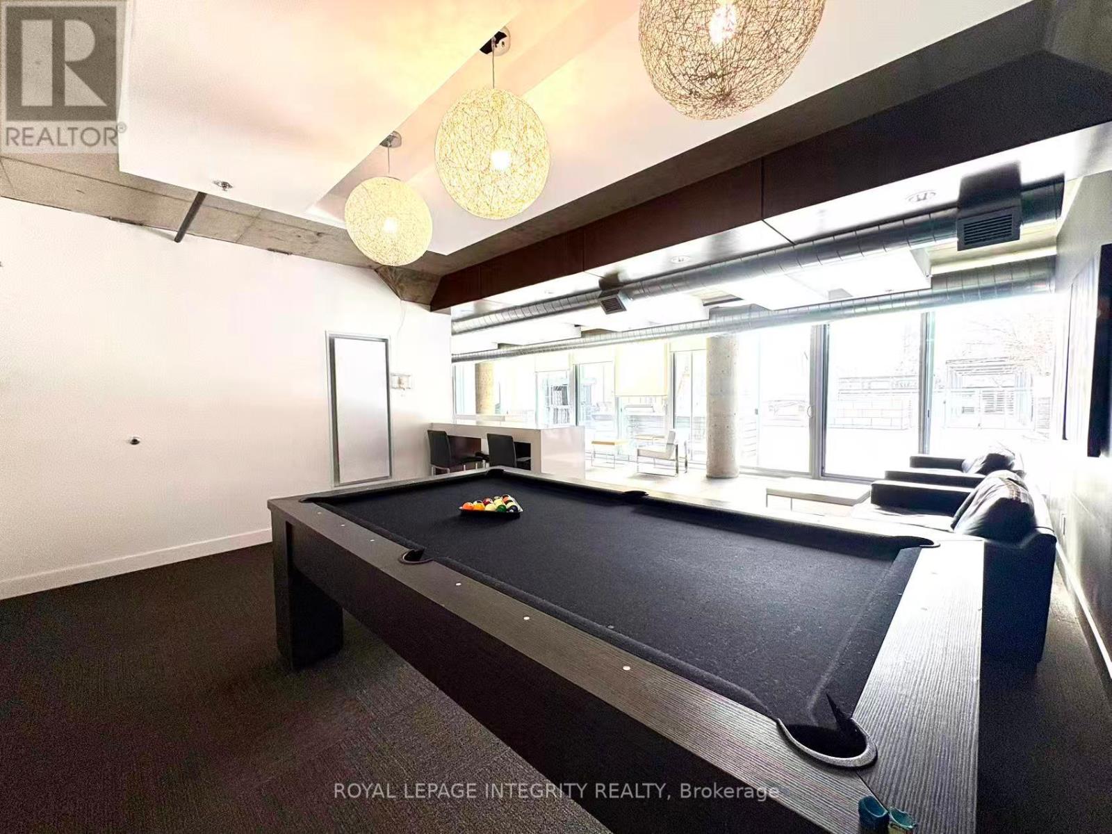 A pool table in a room with a high ceiling and a chandelier.