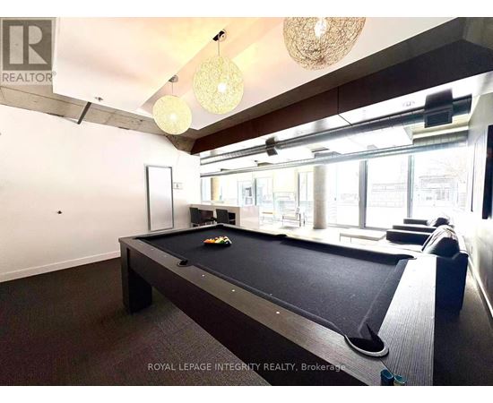 A pool table in a room with a high ceiling and a chandelier.