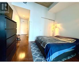 A bedroom with a bed, dresser, and lamp.