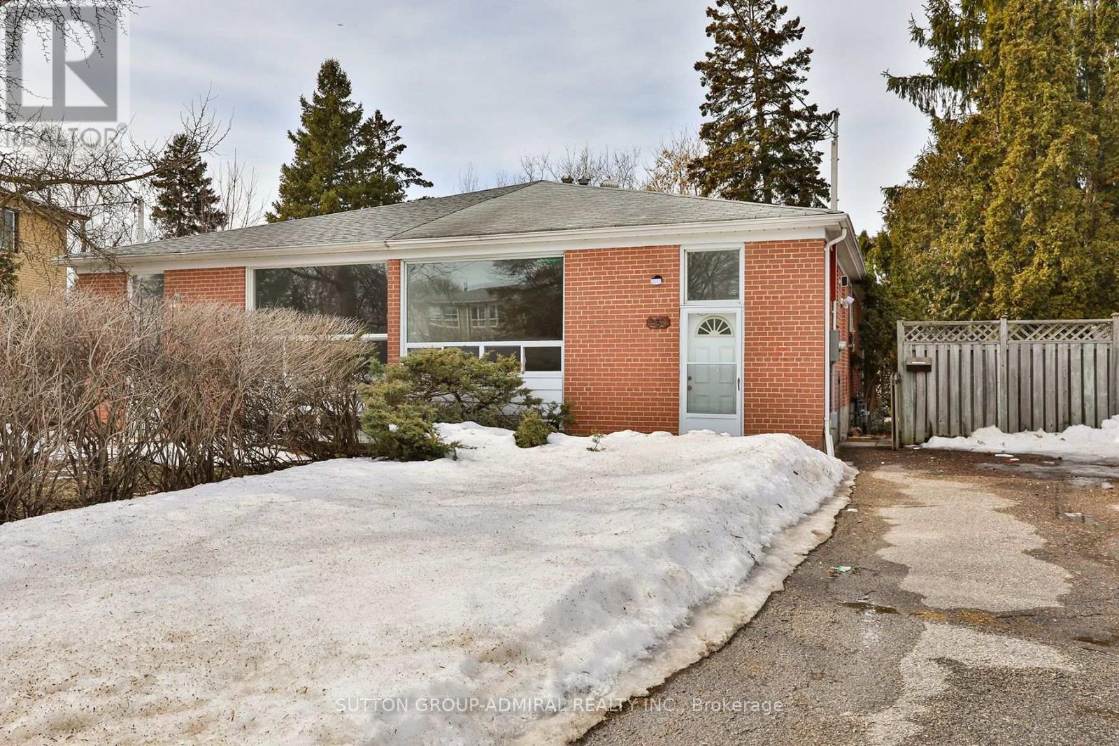 A house with a snow-covered ground in front of it.