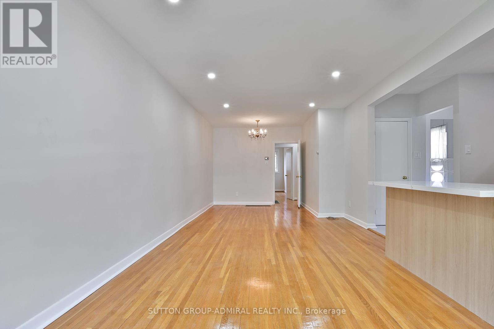 A spacious room with wooden floors and white walls.