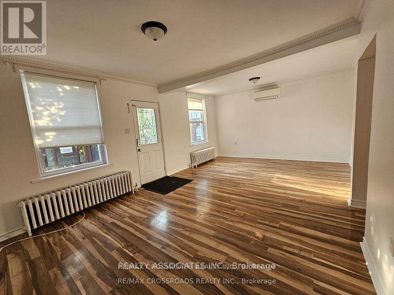 A room with wooden flooring and white walls.