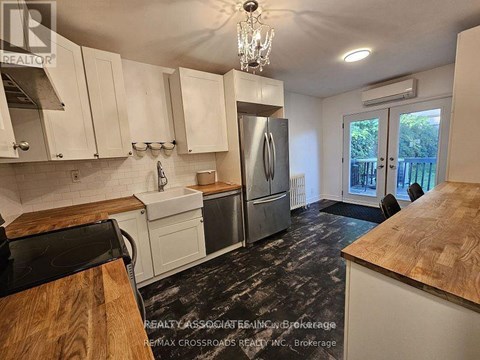 A kitchen with white cabinets and a wooden countertop.