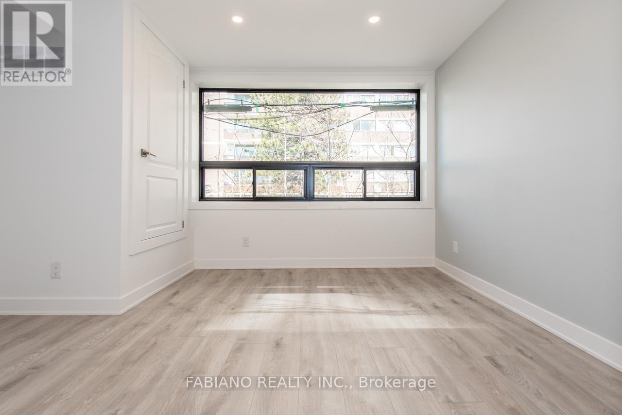 A room with a large window and wooden flooring.