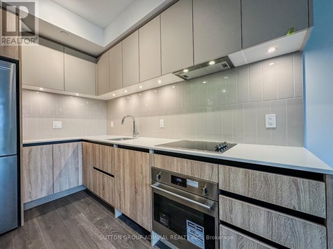A modern kitchen with wooden cabinets and a stainless steel oven.