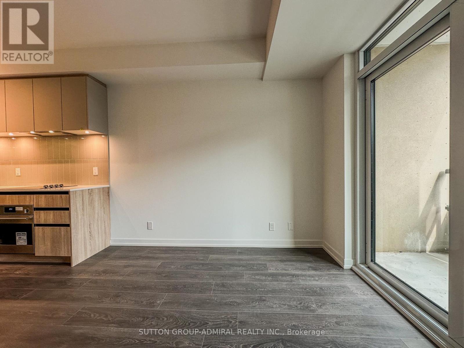 A modern kitchen with wooden cabinets and a large window.