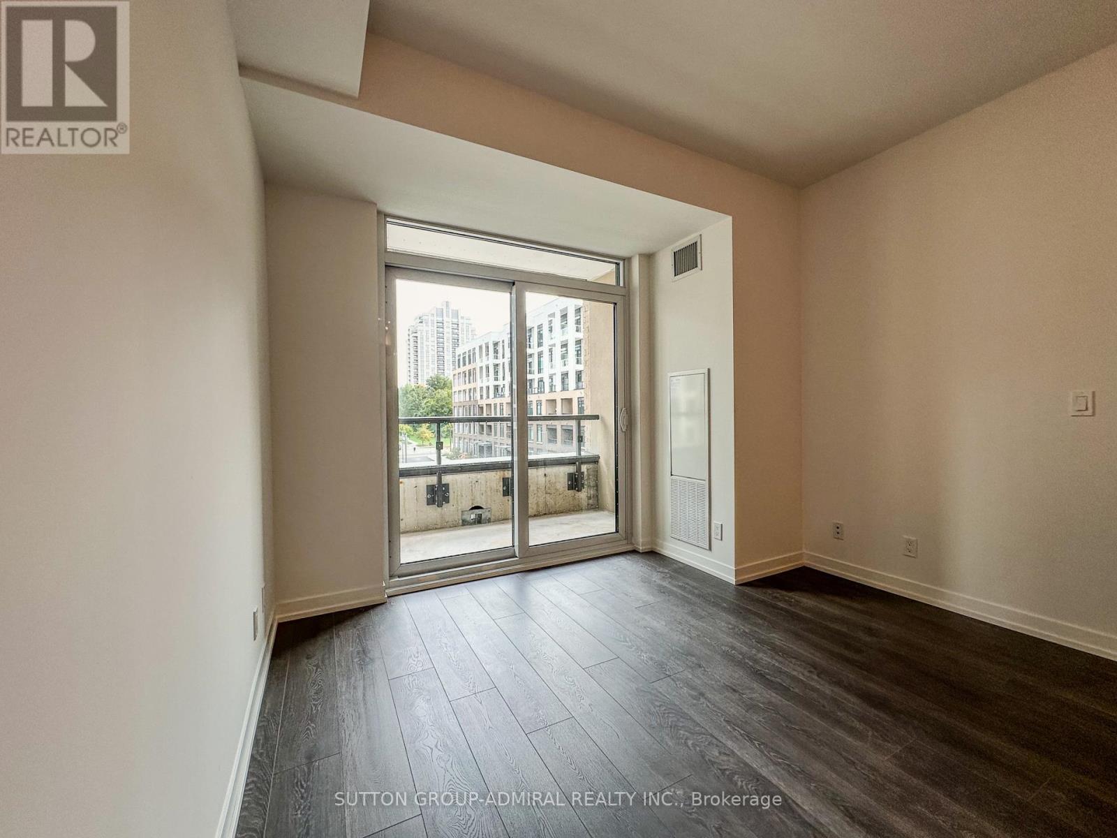 A room with a sliding glass door leading to a balcony.