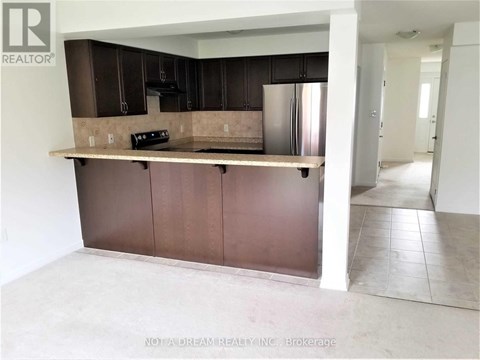A kitchen with brown cabinets and a refrigerator.
