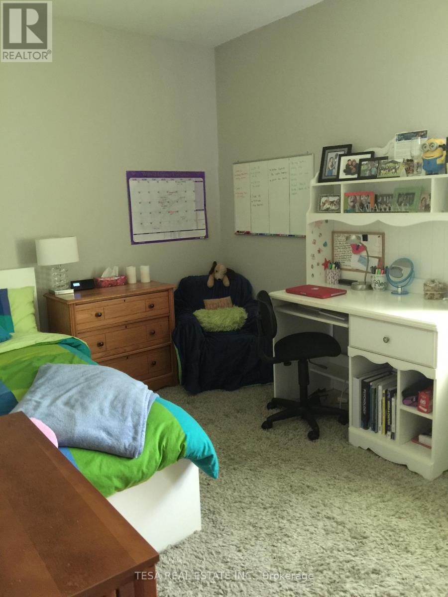 A bedroom with a bed, desk, and chair.