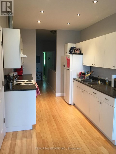 A kitchen with white cabinets and a black counter top.