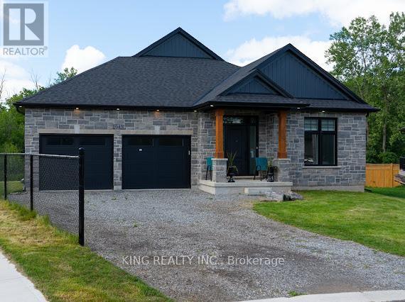 A house with a black roof and stone exterior is for sale.