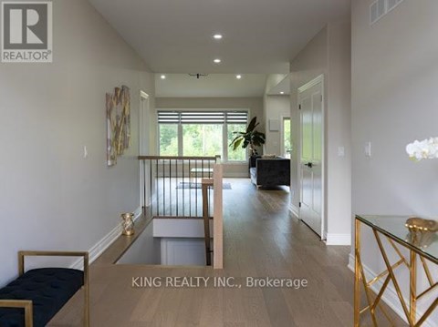 A well-lit, spacious living room with a glass coffee table and a sofa.