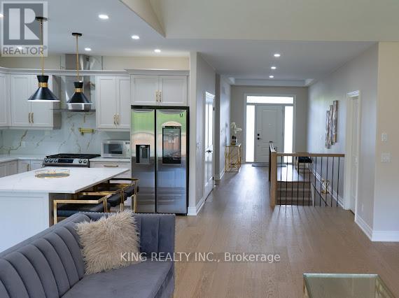 A modern kitchen with a dining table and a grey couch.