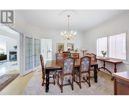 A dining room with a wooden table and chairs.