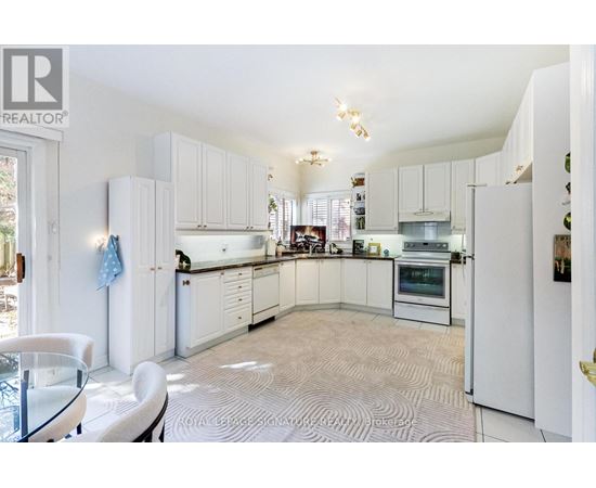 A white kitchen with a glass table and chairs.