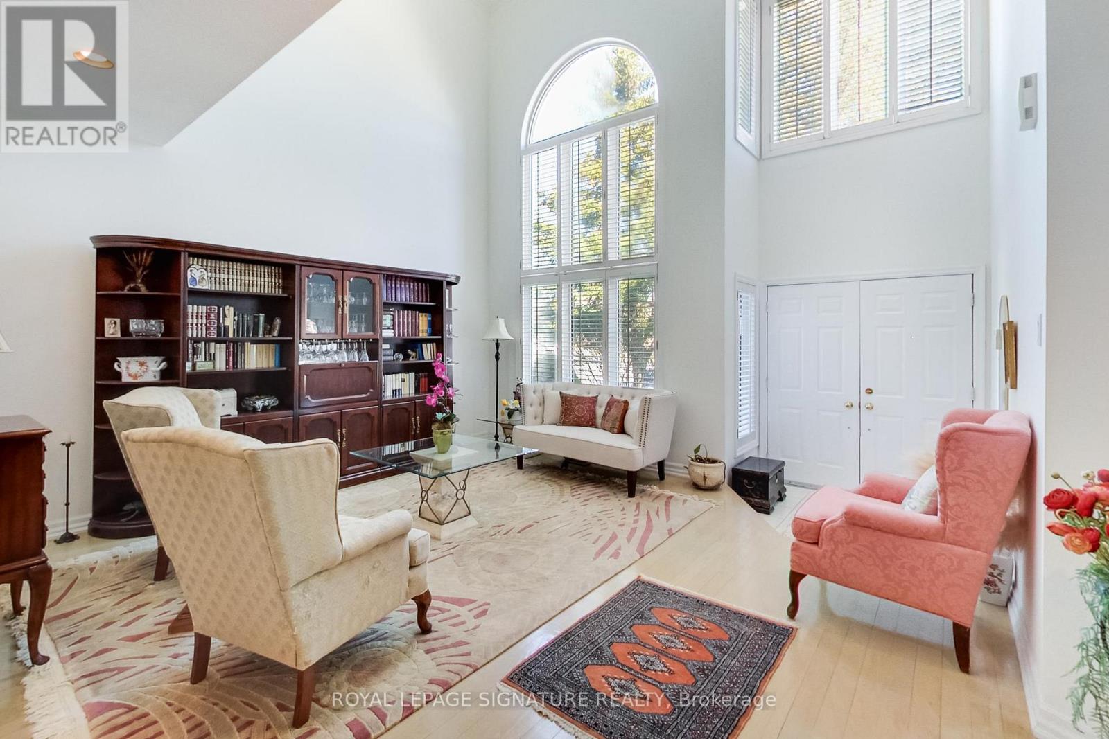A living room with a rug on the floor and a chair in the corner.
