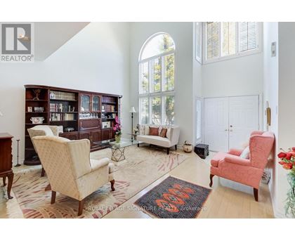 A living room with a rug on the floor and a chair in the corner.