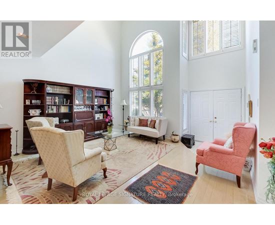 A living room with a rug on the floor and a chair in the corner.