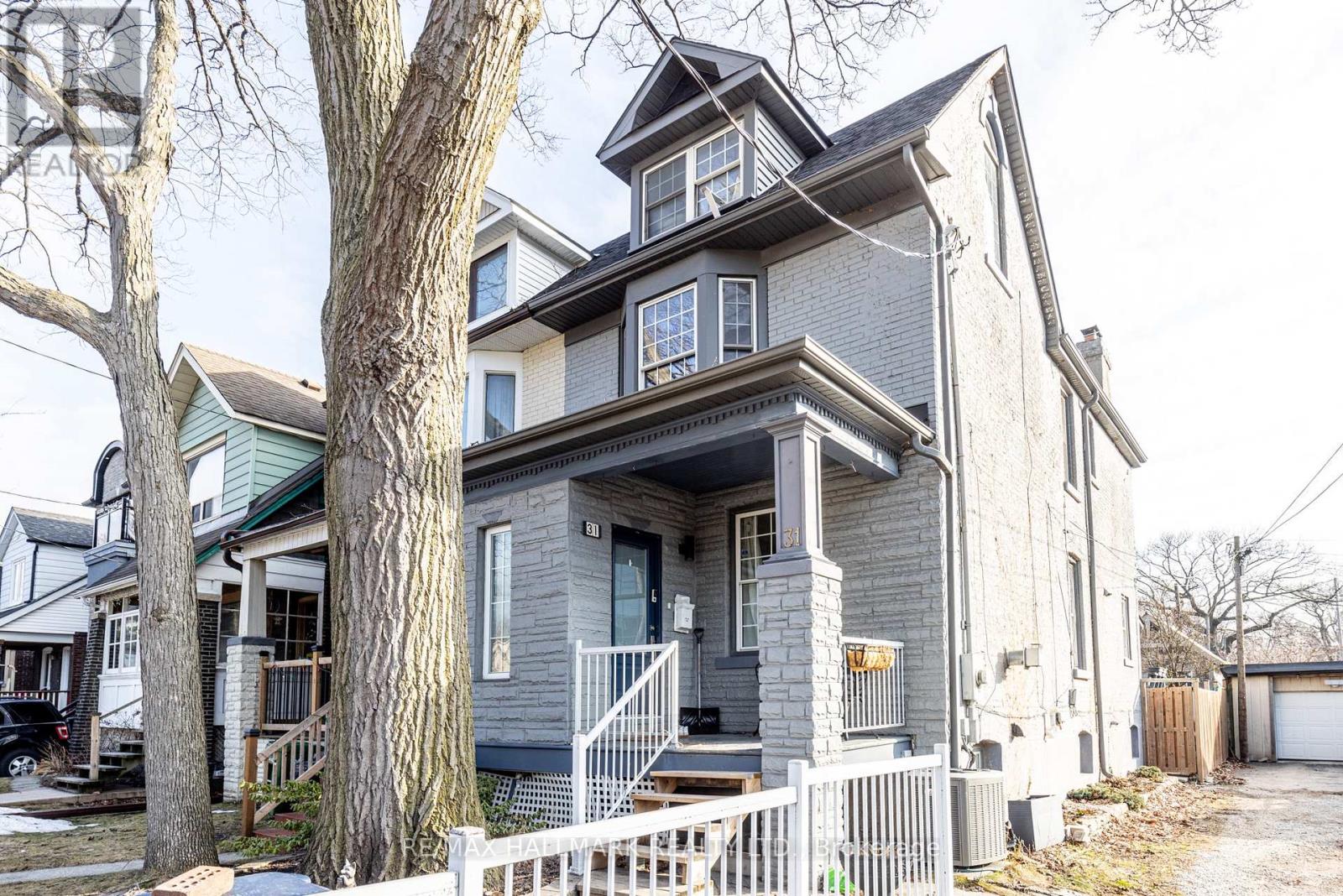 A grey house with a white picket fence in front.