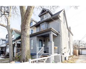 A grey house with a white picket fence in front.