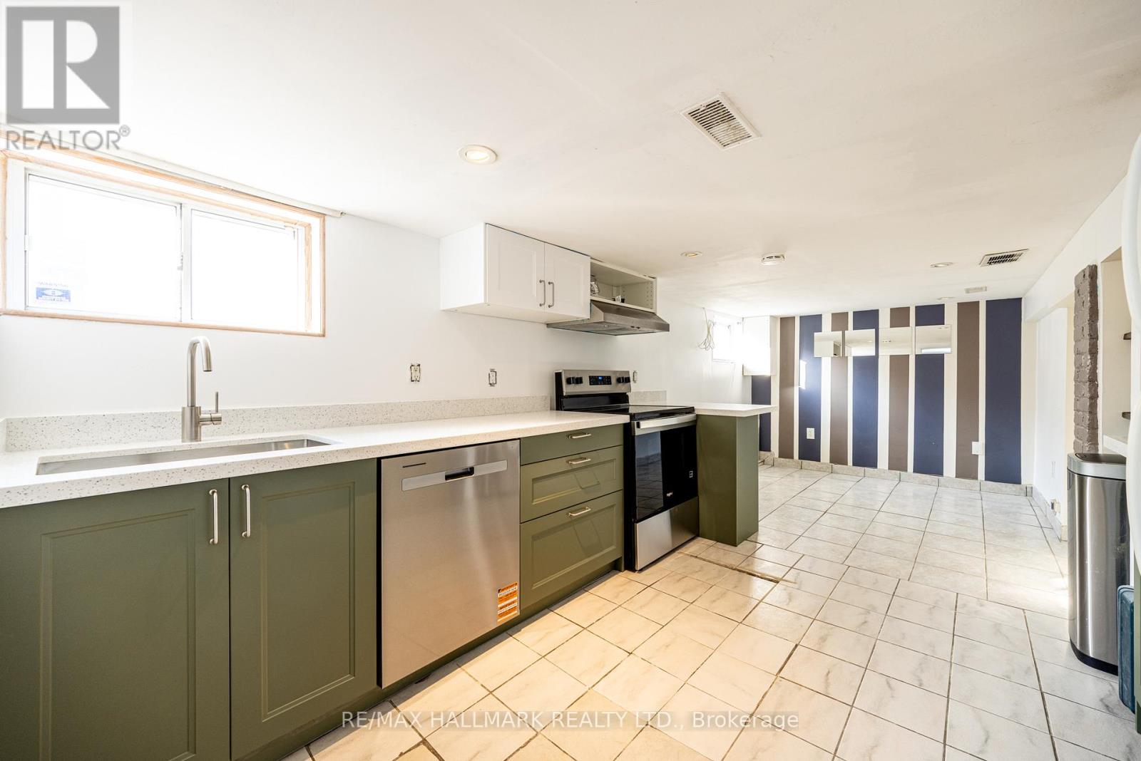A kitchen with green cabinets and a white counter top.