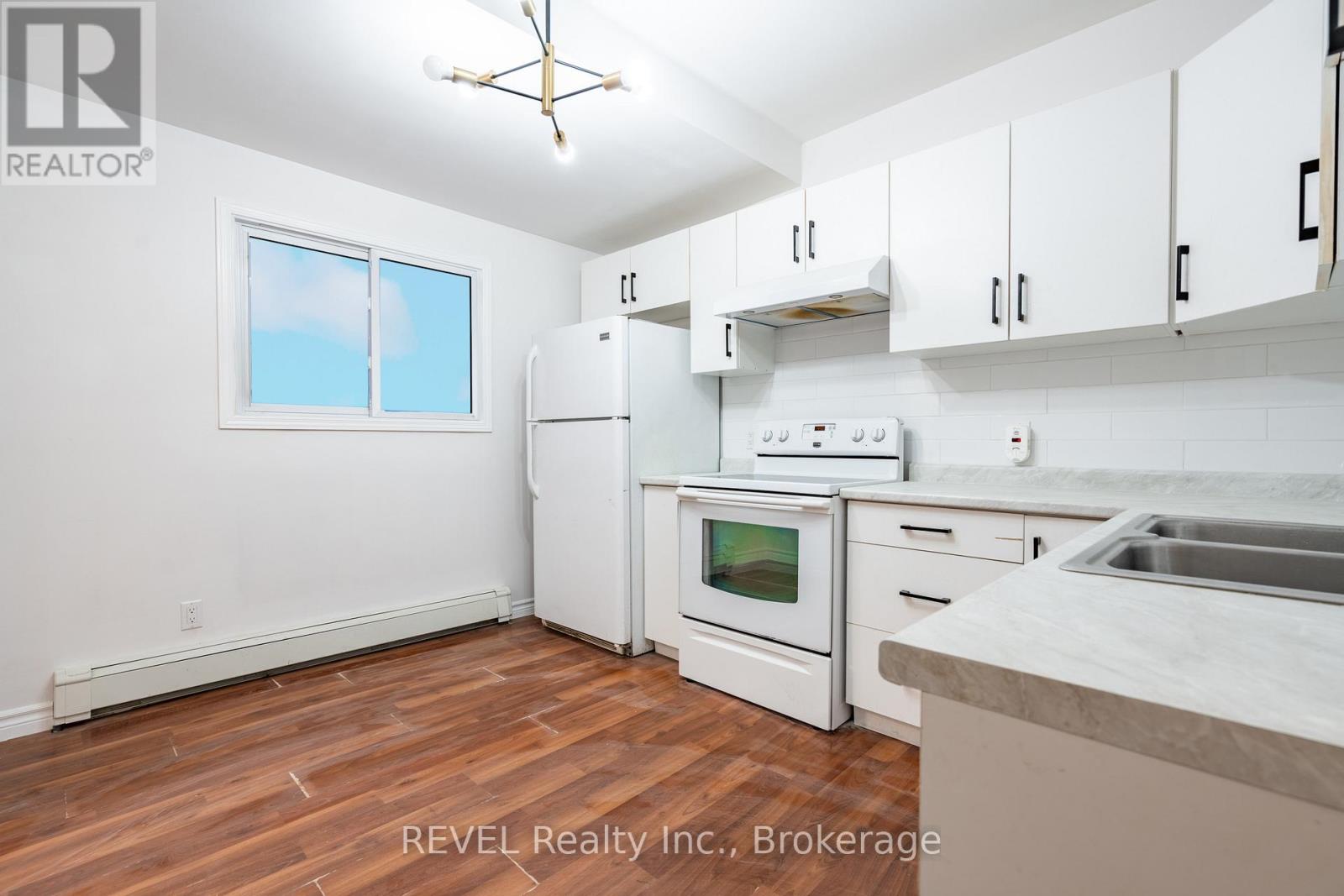 A kitchen with white appliances and cabinets.