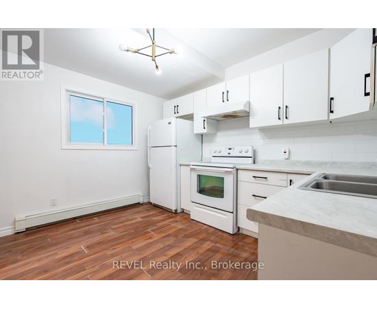 A kitchen with white appliances and cabinets.