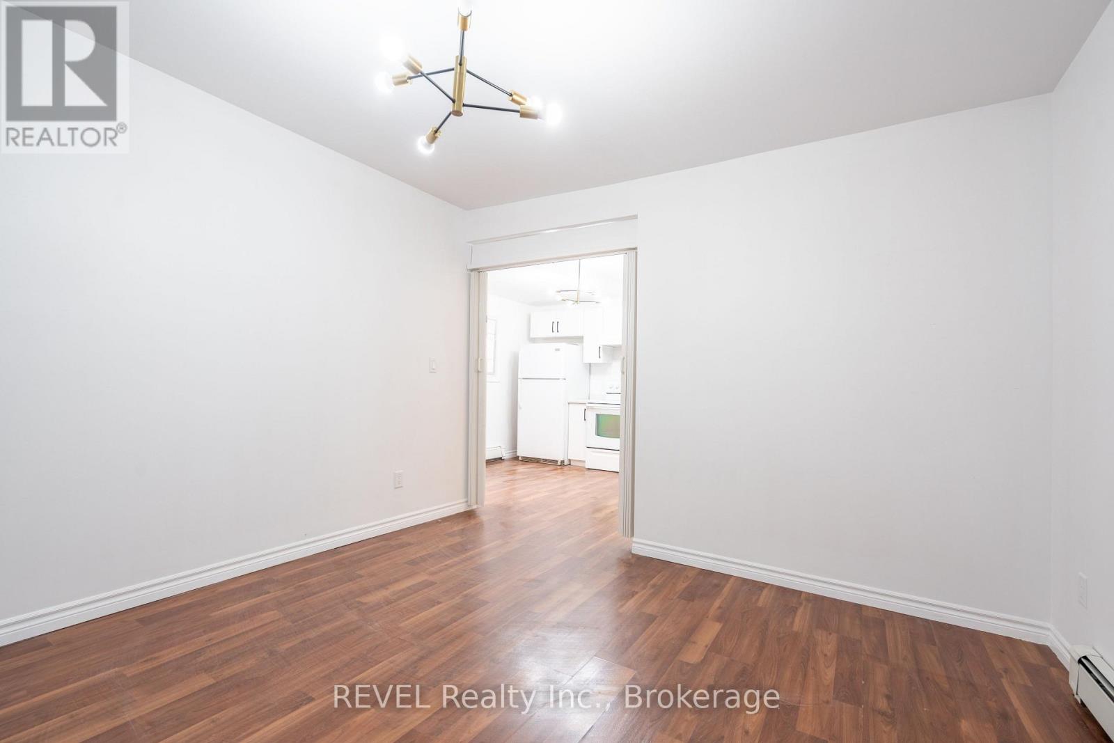 A room with a wooden floor and a white ceiling with a star-shaped light fixture.