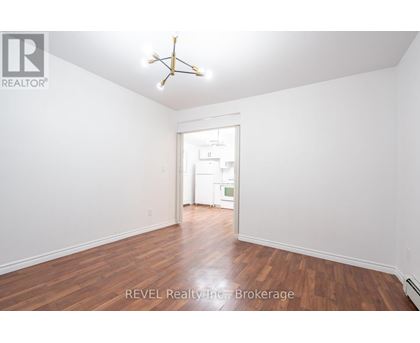 A room with a wooden floor and a white ceiling with a star-shaped light fixture.