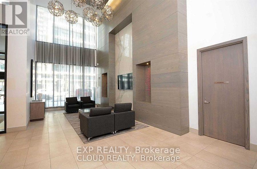 A modern living room with a large window and a chandelier.