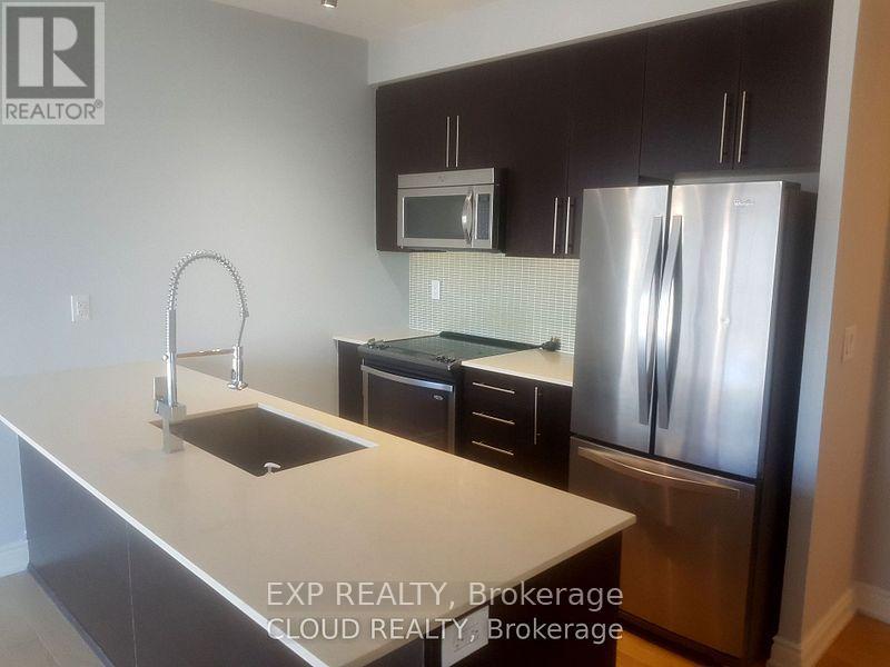 A kitchen with a sink, refrigerator, and microwave.