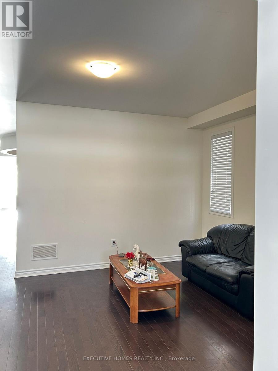 A living room with a black leather couch and a wooden coffee table.