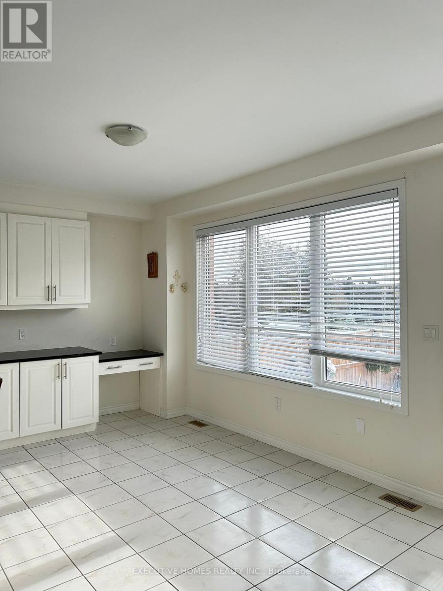 A kitchen with white cabinets and a black countertop.