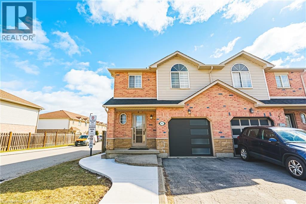 A house with a brick facade and a garage door is for sale.
