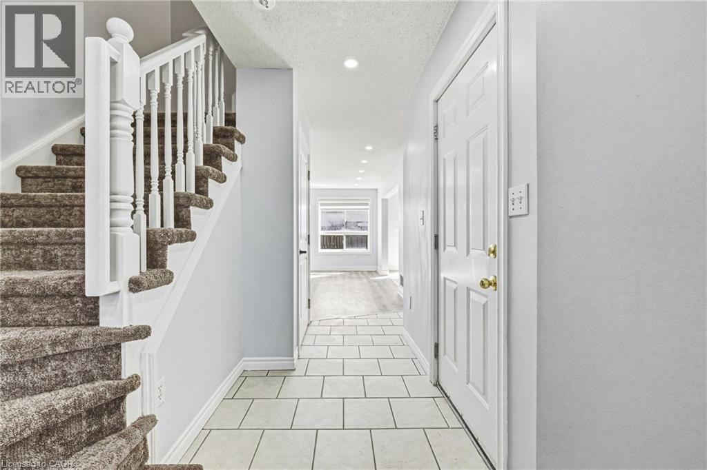 A hallway with a staircase and a door.